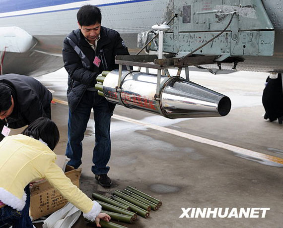 資料圖：2月8日，在河南省鄭州市新鄭機(jī)場(chǎng)，工作人員往飛機(jī)上裝掛人工增雨用的碘化銀催化劑。